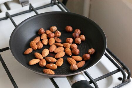 Almonds and hazelnuts roasted nuts in pan on the stoveの写真素材