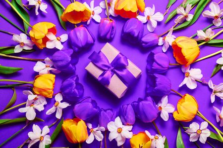 Happy mom day concept. Frame yellow tulips with gift box on lilac backgroundの写真素材