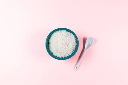 Dry round raw grain rice in a bowl top view on a pink backgroundの写真素材