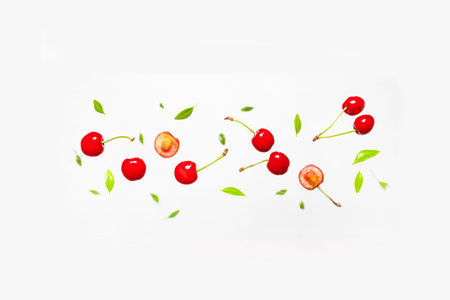 Levitation cherry. Falling cherries with green leaves on grey background.