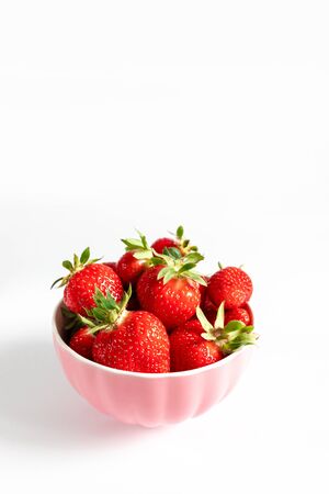 Bowl with fresh strawberries on white background. Summer compositionの写真素材