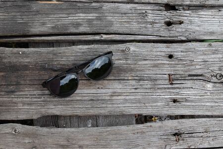 Top view of sunglasses on wooden texture table with copy space.の写真素材