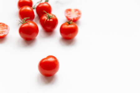 A lot of fresh cherry tomatoes randomly scattered on a white background,flat layの写真素材