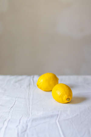 Two citrus lemon on a table on a white wall backgroundの写真素材