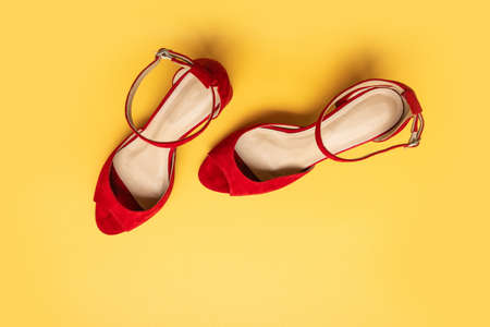 Red womens high heel shoes top view on bright yellow background. Top view, flat layの写真素材