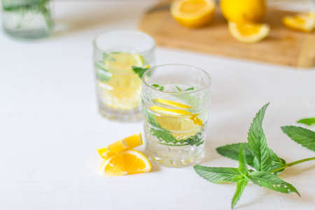 Top view of refreshing lemonade with slices of fruits in glass of drink with ice on white background for summer party. Summer drinks with iceの写真素材