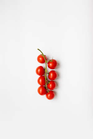 Sprig of ripe fresh cherry tomato on a white background, top view, flat layの写真素材