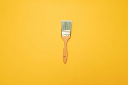 Brush with a nap for painting walls on a yellow background. Top view.の写真素材