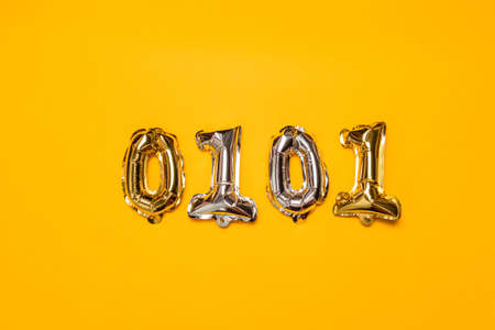 Silver gold glitter metal balls from numbers symbols. Ideal for discount sales on a yellow background. Top view.の写真素材