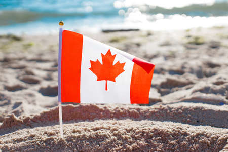 Canada flag on the beach near the sea in sunny weatherの写真素材