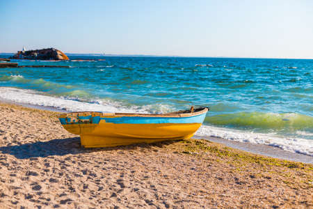 Beautiful seascape view with an old boat on the blue sea beach in sunny weatherの写真素材
