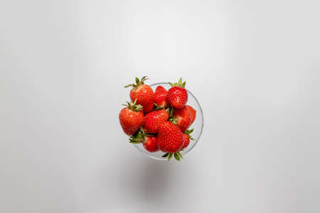 Bowl with fresh strawberries on a white background. Summer compositionの写真素材