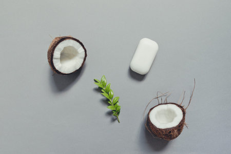Homemade skin care products with coconut, bar soap on gray background