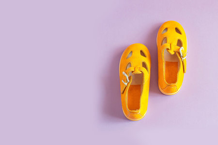 Stylish new yellow shoes on colored pastel background with copyspace, top view, flat lay