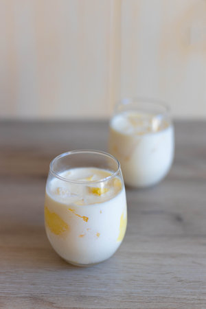 Delicious sweet cream ice cream dessert with melon in glasses on wooden background
