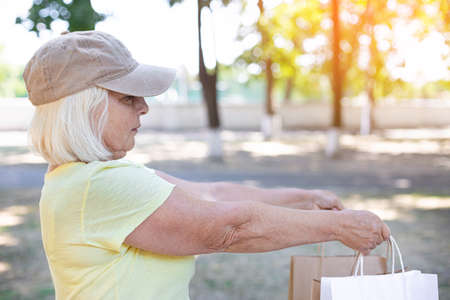 Female delivery courier holds paper bags with groceries to send to customer home. Commercial delivery conceptの写真素材