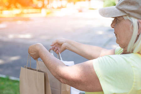 Female courier delivers groceries. Fresh food delivery conceptの写真素材
