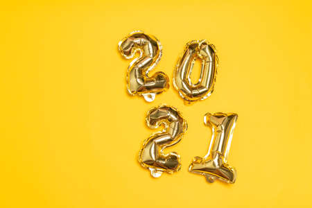 New year 2021 foil balloons on a yellow background with copyspaceの写真素材