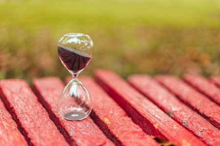 Hourglass on wooden surface with copyspace, vertical photo orientation