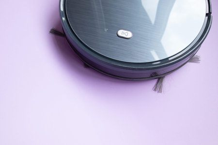 Black robot vacuum cleaner isolated on a purple backgroundの写真素材