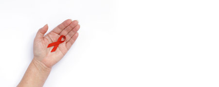 World aids day. Red ribbon on woman hands for world aids day with copy space