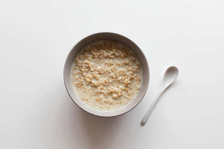Homemade oatmeal porridge with milk in bowl on a white background. Health nutrition food conceptの写真素材