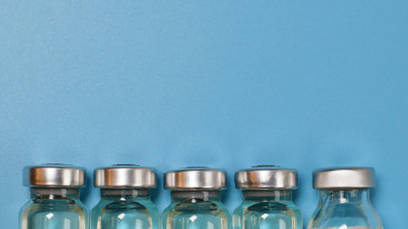 experimental vaccine vials on blue plate with copyspace in a laboratoryの写真素材