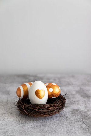 Traditional Easter golden eggs on the nest with copy space on grey background. Decoration for Easter...