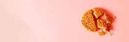 Homemade chip cookies and crumbs isolated on pink background. Minimal composition. Flat lay, top viewの写真素材