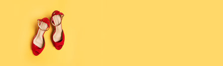 Red female shoes on yellow background. Flat lay, top viewの写真素材