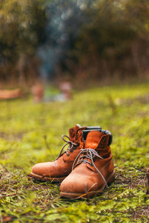 Close up of hiking boots drying out next to campfire during sunsetの写真素材