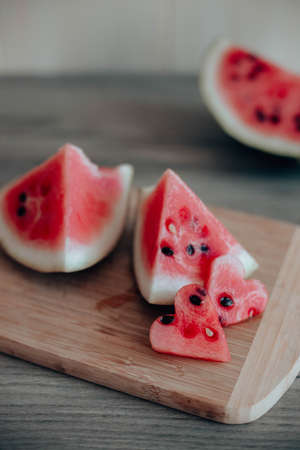 Ripe pieces of watermelon on wooden board in the kitchen. Vertical orientationの写真素材