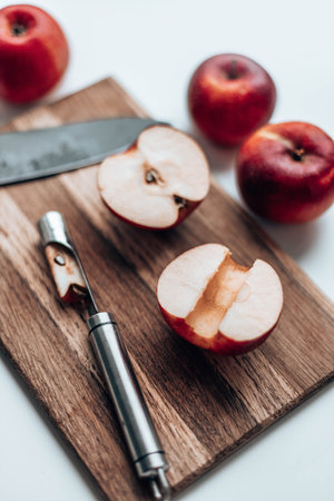 Fresh half an apple on wooden board with a knife on the kitchen table.Top view. Flat lay.