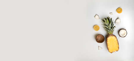 Half ripe pineapple, coconut, lemon on a white plate with copyspaceの写真素材