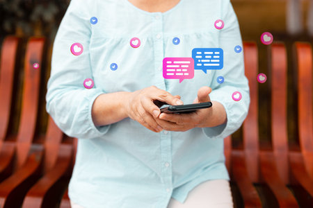Cropped photo of smiling young woman using her mobile phone, reading messages on mobile phone in a...