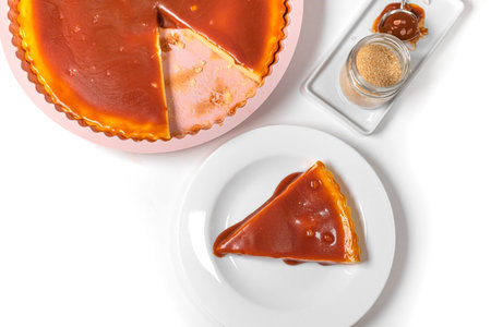 Homemade cheesecake slice with caramel sauce on a white background. Top view. New York cheesecake