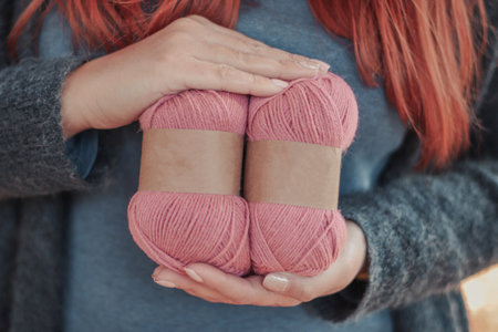 Person hands hold nature wool alpaca yarn balls with blank labelsの写真素材