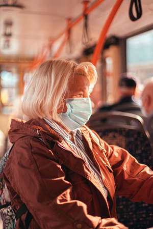 Mature woman wearing surgical protective mask in a public transportationの写真素材