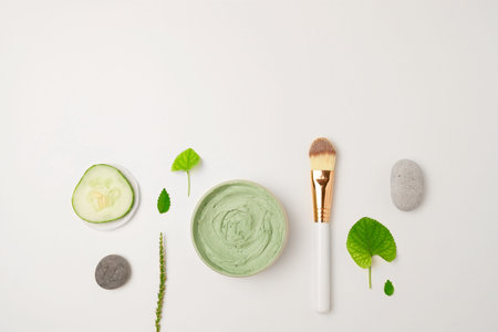 Cosmetic green cream. Composition with organic moisturizer cream jar with eco plant leaves, cucumber...