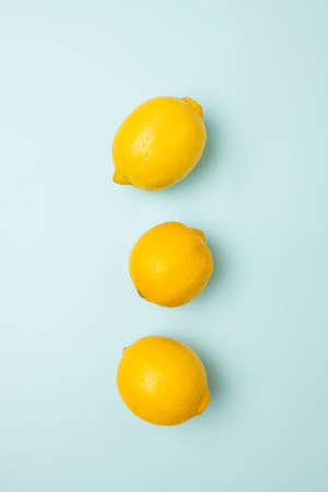 Ripe yellow lemons on bright blue background. Top view. Flat lay pattern, banner. Frame made of fresh lemonsの写真素材