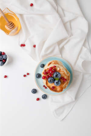 Homemade american pancakes with fresh blueberry, raspberries and honey. Healthy morning breakfast. rustic styleの写真素材
