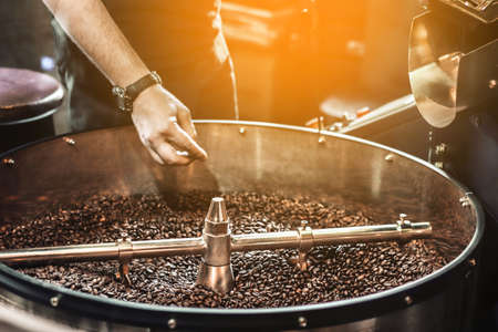 Fresh roasted coffee. Roasting process of coffee beans at factoryの写真素材