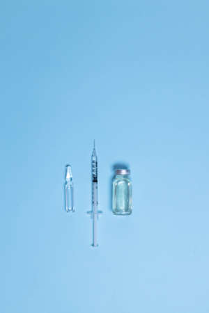 Medical glass vials and syringe for vaccination. liquid drug or vaccine for treatment, flu in laboratory, hospital or pharmacyの写真素材