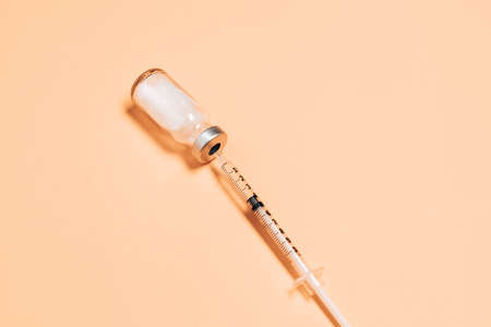 Syringe with medicine from glass vial on light background, flat lay, copyspace. Vaccination against influenza, measles, coronavirus disease.の写真素材