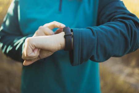 Active sport woman setting up the fitness smart watch for timing running workout.