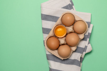 Whisk or egg beater with brown chicken eggs in a eco basket.