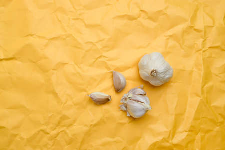 Garlic bulb and garlic cloves on a fifth yellow background. Top view, flat lay.の写真素材