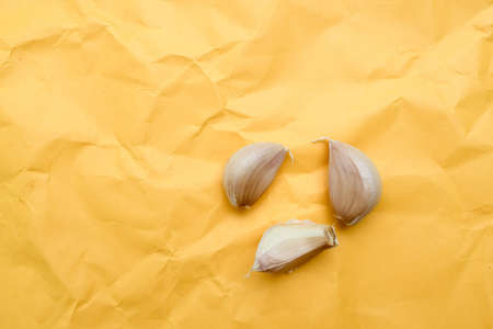 Garlic cloves on fifth yellow background with copy space. Top view, flat lay.の写真素材
