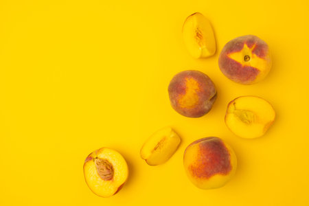 Ripe juicy peaches on yellow background. Flat lay, top view, copy space.の写真素材