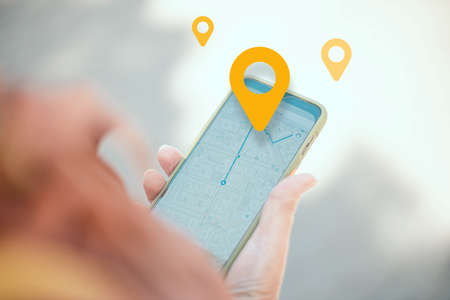 Woman using smart phone with map gps navigation application on screen when traveling at city streetの写真素材